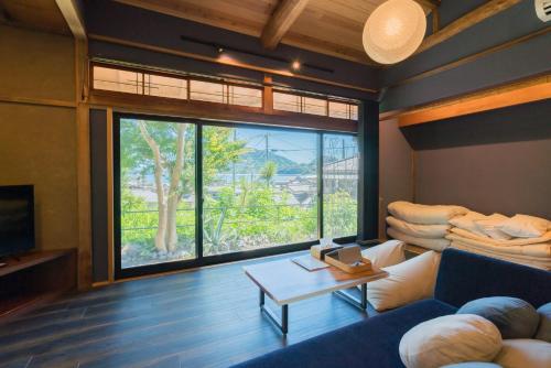 a living room with a blue couch and a large window at 由良民泊島宿 in Matsuyama