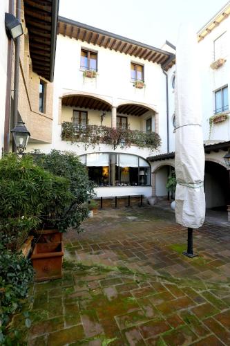 a courtyard of a building with a bench and plants at Locanda Stella d'Oro in Soragna