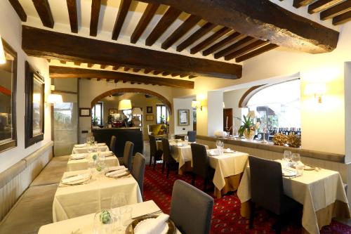 a restaurant with tables and chairs in a room at Locanda Stella d'Oro in Soragna