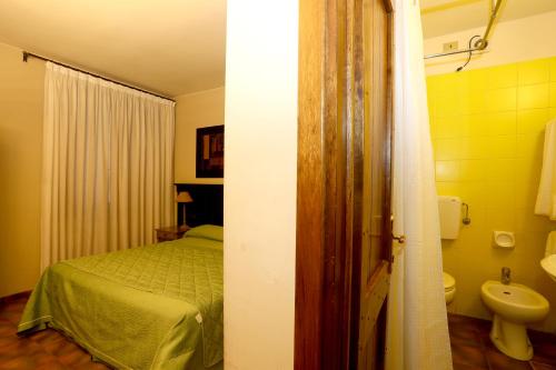 a bedroom with a bed and a bathroom with a sink at Locanda Stella d'Oro in Soragna
