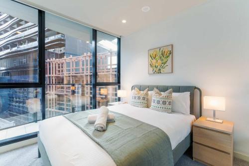 a bedroom with a bed and a large window at Lucia South Yarra Pool Gym free Parking in Melbourne