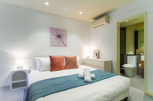 a bedroom with a large white bed with orange pillows at Lucia South Yarra Pool Gym free Parking in Melbourne