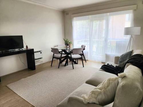 ウィリアムズタウンにあるCosy & Convenient Williamstownのソファとテーブルのあるリビングルーム