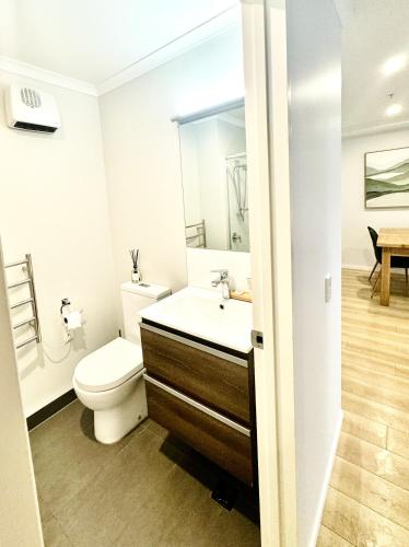 a bathroom with a toilet and a sink at Central City Apartment 'The Olive' in Christchurch