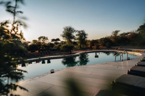 a pool of water in a park with trees at Elephant lodge in Kwa Kuchinia