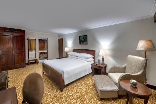 a hotel room with a bed and chairs and a table at Karachi Marriott Hotel in Karachi
