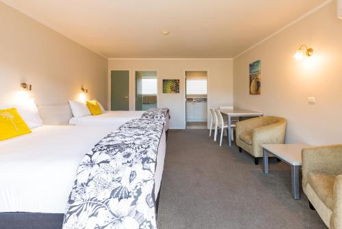 a hotel room with two beds and a couch at Averill Court Motel in Paihia