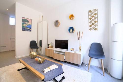 un salon avec une télévision, une table et des chaises dans l'établissement Superb studio with terrace, calm and tranquility, à Cannes