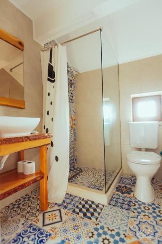 a bathroom with a toilet and a glass shower at La Navod Jurilovca in Jurilovca