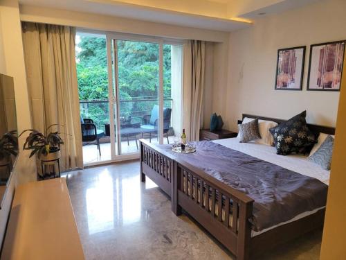 a bedroom with a large bed and a large window at Entire Serviced Apartment in DLF-Phase 2 in Gurgaon