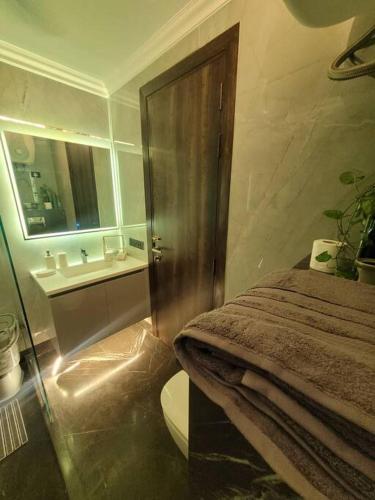 a bathroom with a bed and a sink and a toilet at Entire Serviced Apartment in DLF-Phase 2 in Gurgaon