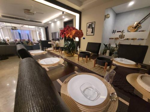 a living room with tables and chairs and a couch at Entire Serviced Apartment in DLF-Phase 2 in Gurgaon