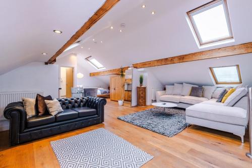 a living room with two couches and a rug at The Loft Apartments | Cheadle in Cheadle Hulme