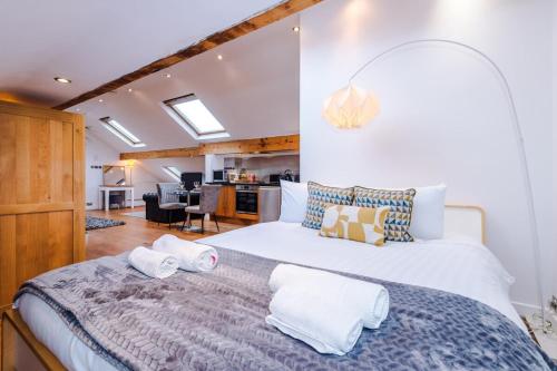 a bedroom with a large bed with towels on it at The Loft Apartments | Cheadle in Cheadle Hulme
