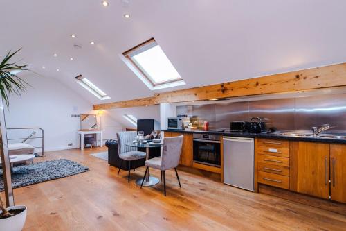 a kitchen with a table and a dining room at The Loft Apartments | Cheadle in Cheadle Hulme