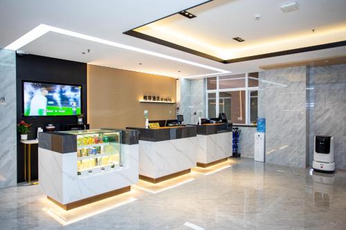 a lobby with a bar with a tv in it at VX Hotel Shanghai Yixian Road Dabaishu in Shanghai