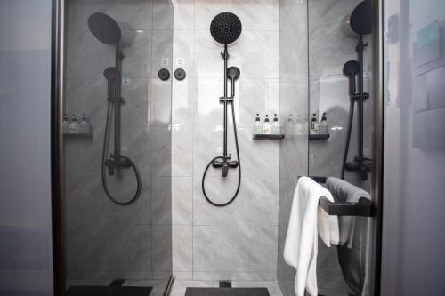 a bathroom with a shower with a shower head at VX Hotel Shanghai Yixian Road Dabaishu in Shanghai