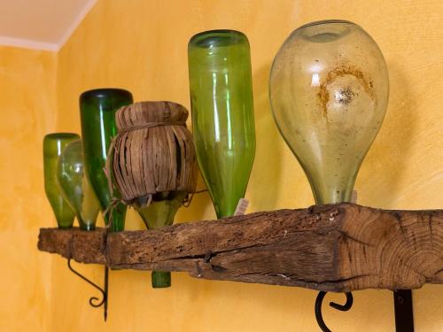 a shelf with green glass vases on a wall at Nel Caruggio - B&B in Mornese