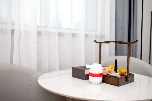 a white table with a drink and a cup on it at VX Hotel Shanghai Yixian Road Dabaishu in Shanghai