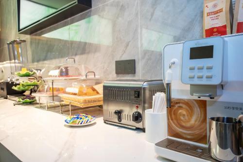 a kitchen counter with a coffee maker and a mixer at VX Hotel Shanghai Yixian Road Dabaishu in Shanghai