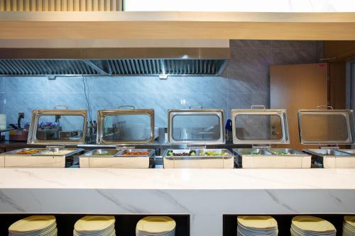 a buffet line of food in a restaurant at VX Hotel Shanghai Yixian Road Dabaishu in Shanghai
