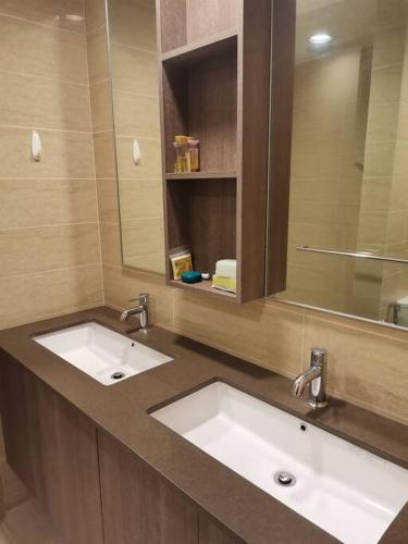 a bathroom with two sinks and a mirror at By The Sea Beach Front Sea view Apartment 3 in Batu Ferringhi