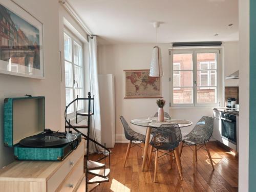 une cuisine avec une table et des chaises et une télévision dans l'établissement Pastel au grenier à sel, à Colmar