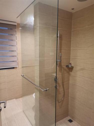 a shower with a glass door in a bathroom at By The Sea Beach Front Sea view Apartment 3 in Batu Ferringhi