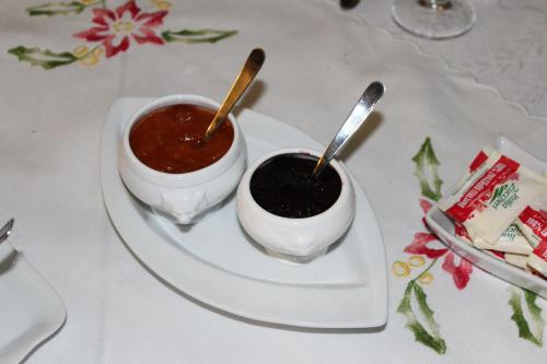 a white plate with two bowls of sauce on a table at B&B Elda Country House in Chiassa Superiore