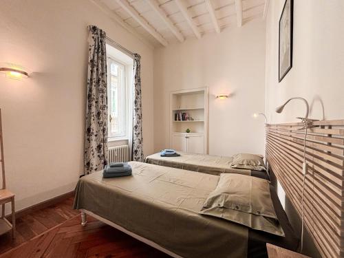 a bedroom with two beds and a window at La tua casa nel cuore di Torino in Turin