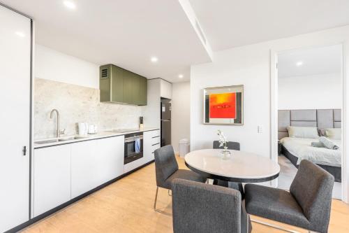 a kitchen and living room with a table and chairs at Central located 2 bedroom Apartment in Canberra with Parking in Canberra