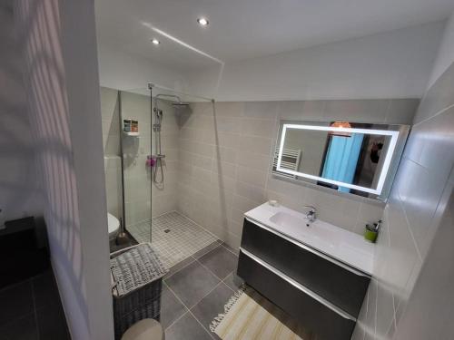 une salle de bain blanche avec un lavabo et une douche dans l'établissement Charmante villa avec jardin, à Prunete