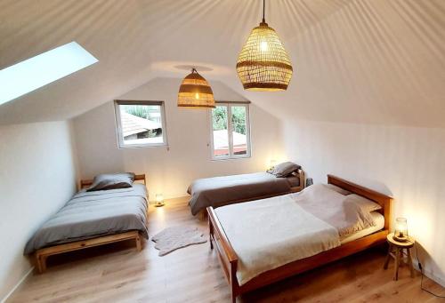 une chambre avec deux lits et deux fenêtres dans l'établissement Maison 115 m2 village alsacien, à Eckwersheim