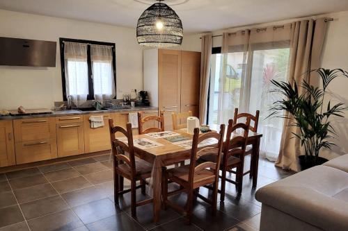 une cuisine et une salle à manger avec une table et des chaises dans l'établissement Charmante villa avec jardin, à Prunete