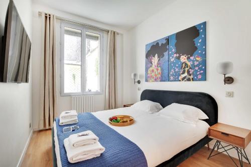 une chambre avec un lit avec un bol de fruits dessus dans l'établissement Spacious Apartment - 2BR-4P - Place de Clichy, à Paris