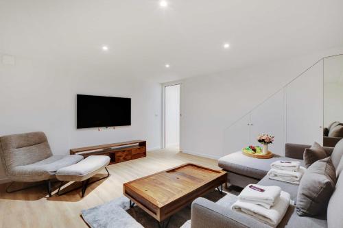 un salon avec un canapé et une télévision dans l'établissement Spacious Apartment - 2BR-4P - Place de Clichy, à Paris