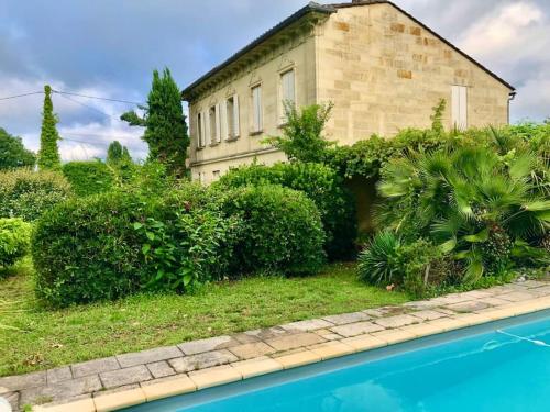 une maison avec une piscine devant dans l'établissement La Dame de Onze Heures, à Saint-Émilion