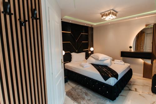 a bedroom with a bed and a chandelier at Hotel Casa Blanca in Tulgheş
