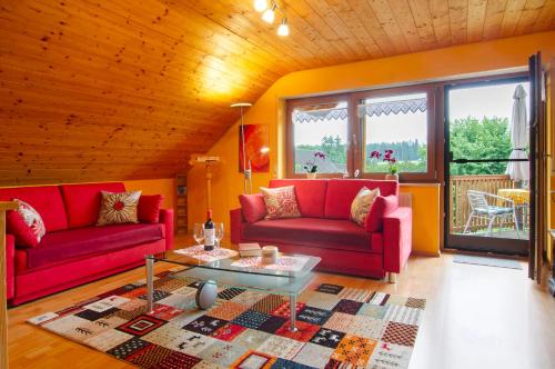 a living room with two red couches and a table at Ferienwohnung Schank in Sauldorf