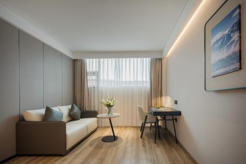 a living room with a couch and a table at Atour Hotel -Du Fu Thatched Cottage in Chengdu