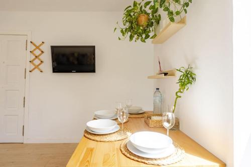 a wooden table with plates and glasses on it at Osa Mayor Apartment Bajamar in Bajamar