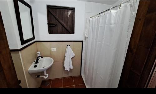 a bathroom with a sink and a white shower curtain at CHALET PRIVADO, PISCINA, WIFI AL MEJOR PRECIO in San Juan de la Rambla