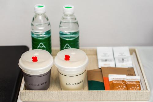 a tray with two bottles of water and two cups at Atour Hotel -Du Fu Thatched Cottage in Chengdu