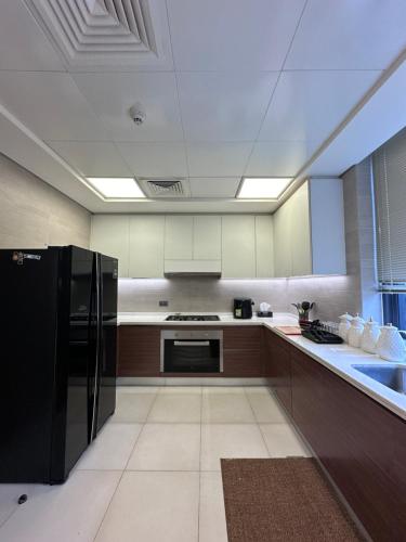 a kitchen with a black refrigerator and a sink at Villa in Yas Island , Abu Dhabi in Yas Island