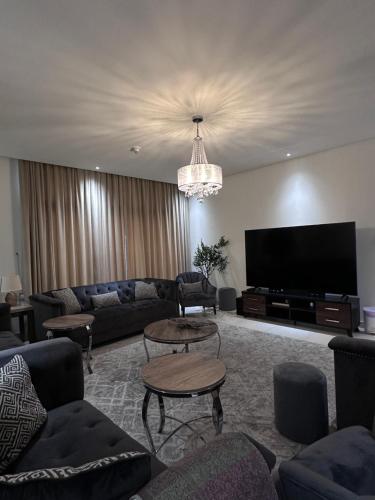 a living room with couches and a flat screen tv at Villa in Yas Island , Abu Dhabi in Yas Island