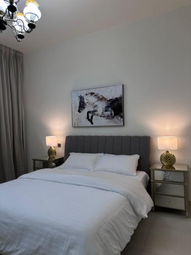 a bedroom with a large white bed with two night stands at Villa in Yas Island , Abu Dhabi in Yas Island