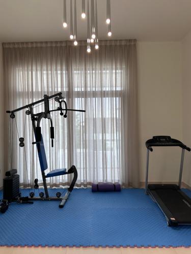 a room with a gym with a treadmill and a room with a window at Villa in Yas Island , Abu Dhabi in Yas Island