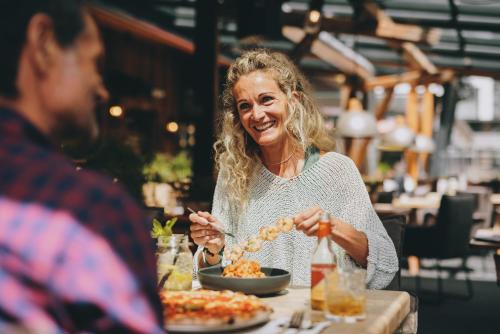 a woman sitting at a table eating food at THOMSN Central Hotel & Appartements in Saalbach Hinterglemm