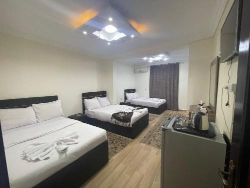 una habitación de hotel con dos camas y un sofá en Pyramids High View Inn, en Giza