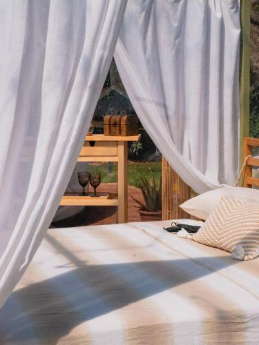 a bedroom with a bed with white curtains at Folià - Natural Experience in San Vito dei Normanni